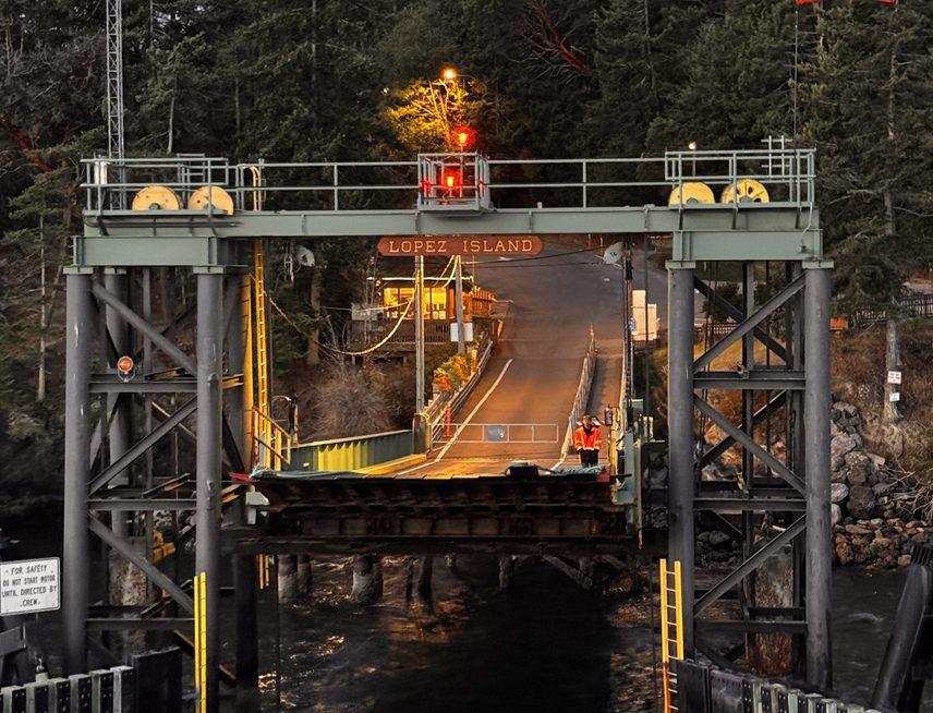 The Lopez Island ferry dock at dusk, ramp lights on and the water still